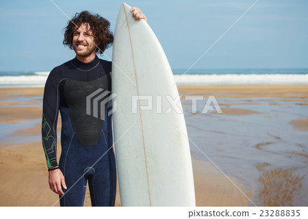 Surfer standing on the beach with beautiful ocean 23288835
