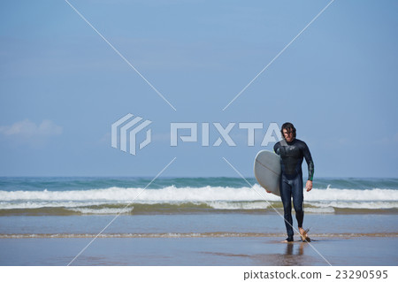 Sporty male is walk with surfboard near sea Sporty male is walk with surfboard near sea 23290595