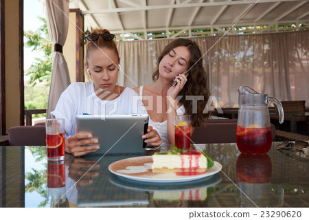 Ladies using touch pad and cell telephone  23290620