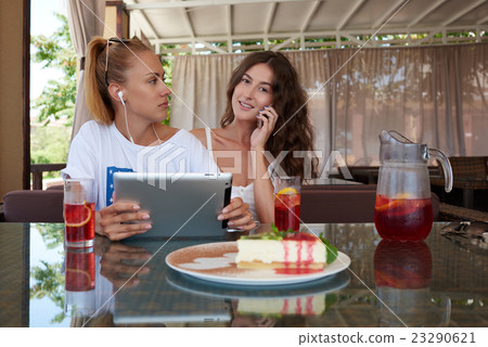 Hipster girls using cell telephone and tablet Hipster girls using cell telephone and tablet 23290621