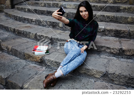 Student girl taking a self portrait with phone Student girl taking a self portrait with phone 23292253