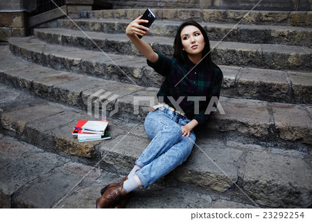 Girl taking a self portrait with smart phone Girl taking a self portrait with smart phone 23292254
