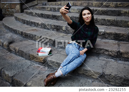 Charming girl smiling while taking a self-ie Charming girl smiling while taking a self-ie 23292255