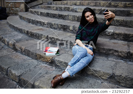 Girl smiling while taking a self-ie outdoors 23292257