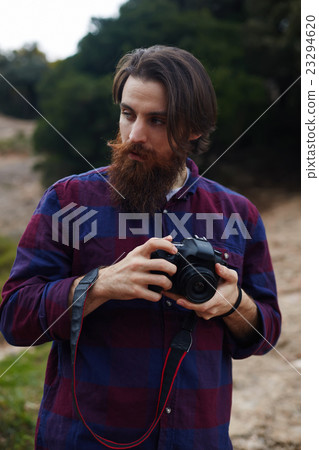 Bearded man taking photo with his digital camera Bearded man taking photo with his digital camera 23294620