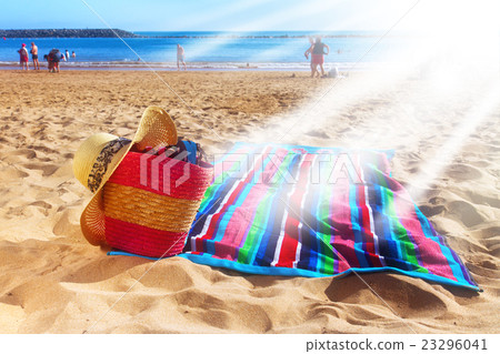towel and  basket on sandy beach 23296041
