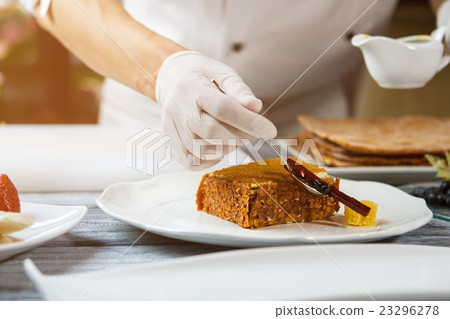 Hand with spoon beside cake. Hand with spoon beside cake. 23296278