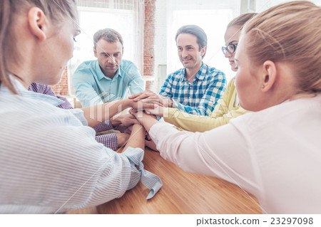 Coworkers stacking hands Coworkers stacking hands 23297098