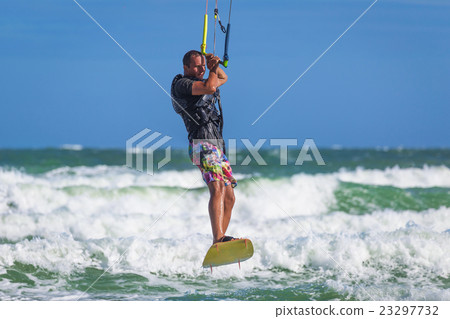 Athletic man riding on kite surf board sea waves 23297732