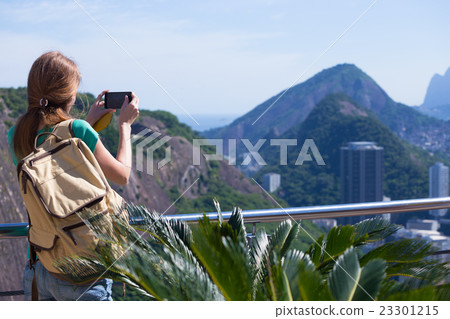 girl tourist takes a picture of Rio landscape with smartphone 23301215