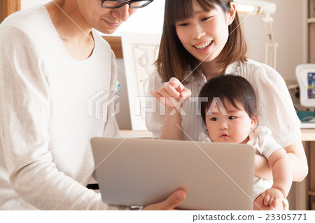 A young family watching a computer 23305771