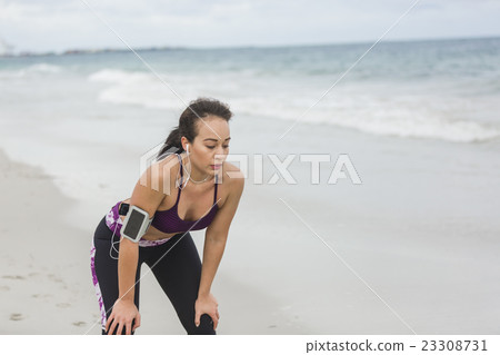 Fitness Woman resting after work out on the beach Fitness Woman resting after work out on the beach 23308731