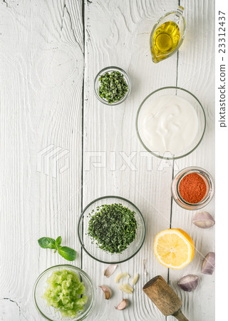 Natural yogurt and different seasoning on  table 23312437