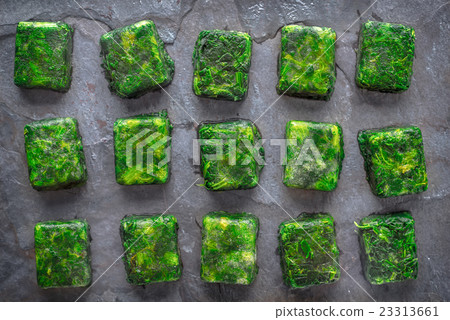 Cubes of frozen spinach on the stone table Cubes of frozen spinach on the stone table 23313661