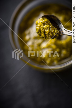 Pesto sauce in the metal spoon with blurred 23314073