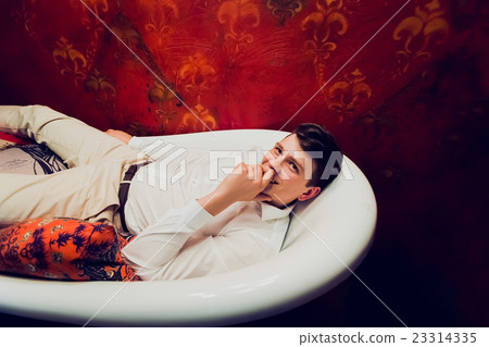 Young man lies in the clothes in the bathroom 23314335