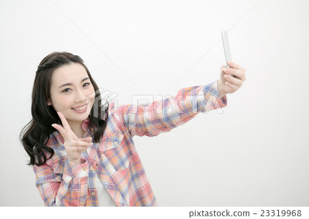 Woman taking pictures with a smartphone Woman taking pictures with a smartphone 23319968