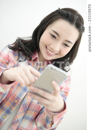 A woman operating a smartphone A woman operating a smartphone 23319970