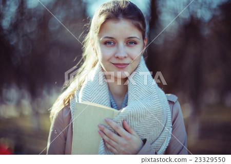 girl in autumn park with a book 23329550