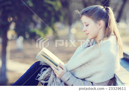 girl in autumn park with a book 23329611