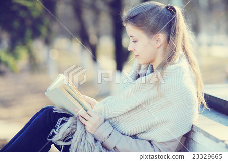 girl in autumn park with a book 23329665