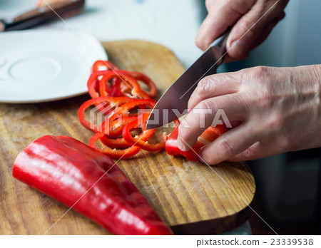 Woman is chopping red bell pepper Woman is chopping red bell pepper 23339538