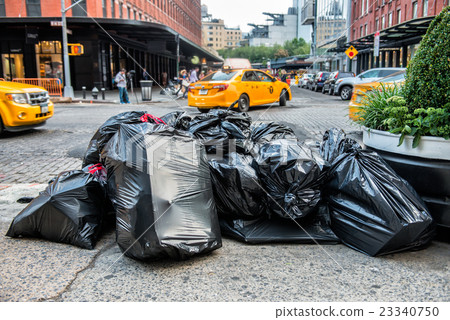 Black bags of trash on sidewalk in New York City  23340750