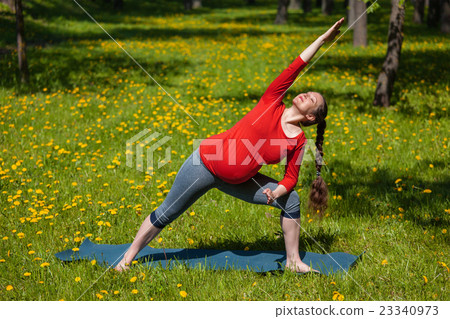 Pregnant woman doing asana Utthita parsvakonasana 23340973