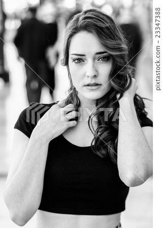 Beautiful young woman with blue eyes in urban background 23347388