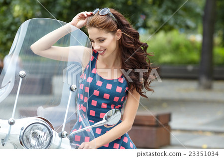 Young  italian woman sitting on a vintage scooter 23351034