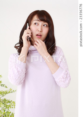 一位年輕的女士驚訝於電話 23356776