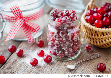 Cranberries with sugar in jar, basket with berries 23360164