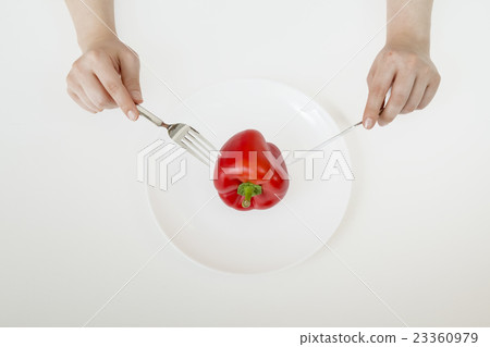 Diet image eating red paprika with a fork and a knife 23360979