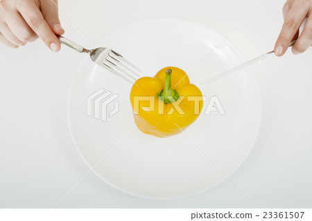 Diet image eating yellow paprika with fork and knife 23361507