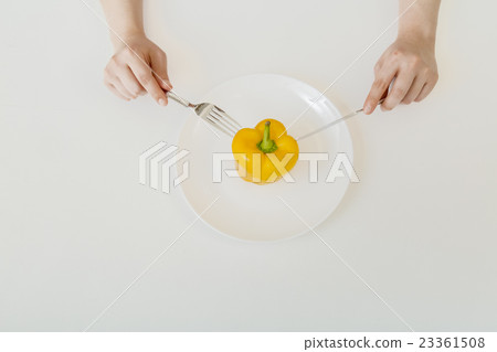 Diet image eating yellow paprika with fork and knife 23361508