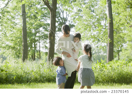 A family playing in a fresh green park 23370145