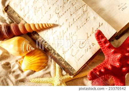 Seashells and old book on sand Seashells and old book on sand 23370542