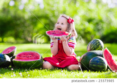 Little girl eating watermelon in the garden 23373985