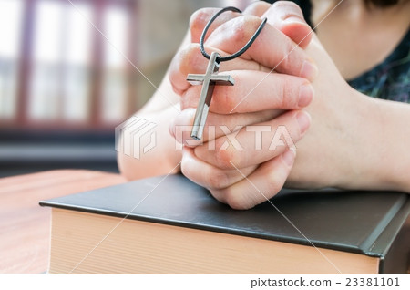 Prayer holds cross and is praying in church. 23381101