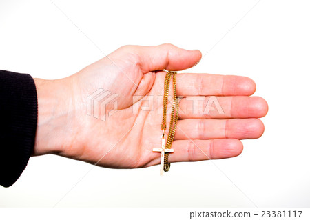 Hand holds a chain with gold crucifix 23381117