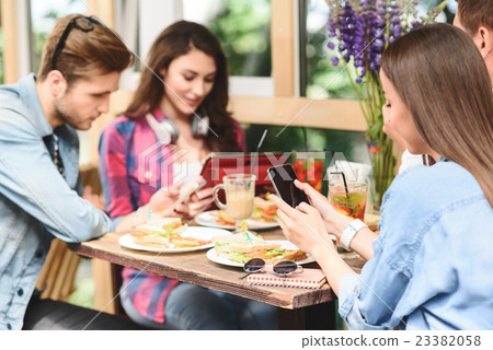 Happy friends having lunch in cafe Happy friends having lunch in cafe 23382058