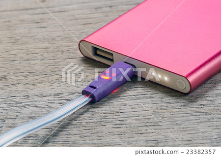 Red power bank on wooden background. Red power bank on wooden background. 23382357