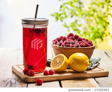 Ice cold drink glass with raspberry and lemon Ice cold drink glass with raspberry and lemon 23385061