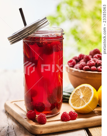 Ice cold drink glass with raspberry and lemon 23385063