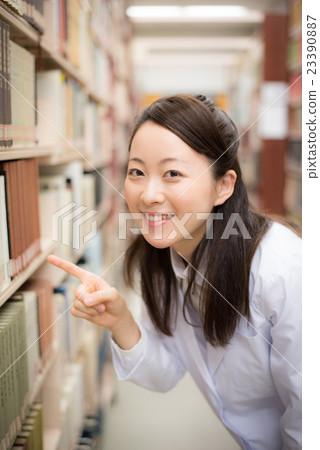 Woman in library white garment Woman in library white garment 23390887