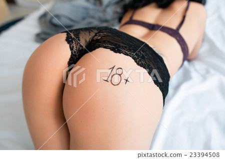 Bending woman in bed with label 18plus on ass Bending woman in bed with label 18plus on ass 23394508