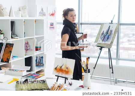 Female painter drawing in art studio using easel Female painter drawing in art studio using easel 23394531
