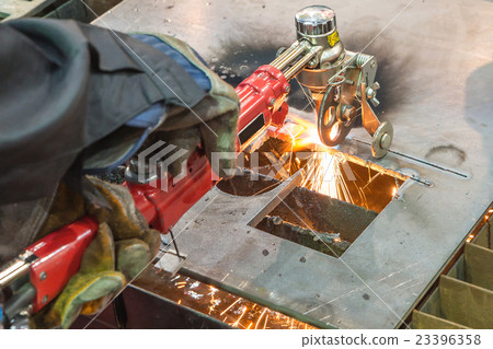 Worker cutting metal with grinder. 23396358