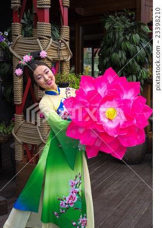 woman in traditional chinese dress and pink flower woman in traditional chinese dress and pink flower 23398210