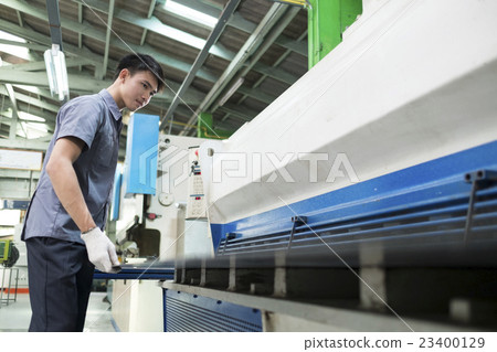 Man controlling hydraulic press machine  23400129